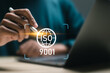 ISO 9001 Standard certification standardisation quality control concept, businessman use laptop with virtual screen of ISO 9001 symbol for quality management of organizations.