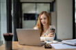 © Wasana - Businesswoman sitting and enjoying hot coffee, pay attention on the laptop screen while relaxing.