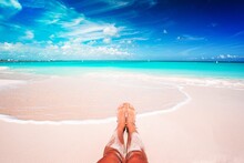 Young Woman Sunbathing On White Beach. Legs.