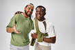© LIGHTFIELD STUDIOS - smiling african american male friends in casual wear hugging on grey background, Juneteenth