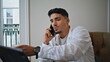 © stockbusters - Relaxed guy calling cellphone at home closeup. Serious man drinking cola at home