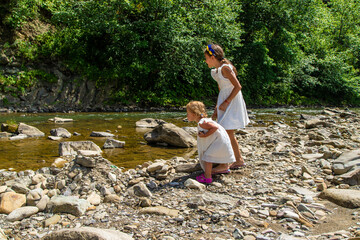 Poster - Children throw stones into the river. Selective focus.