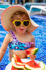 Poster - Children eat watermelon near the pool. Selective focus.