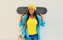 Portrait Of Happy Smiling Young African Woman Model Posing With Skateboard In The City