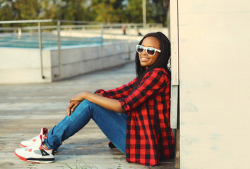 Wall Mural - Portrait of stylish young african woman with dreadlocks posing wearing casual in the city