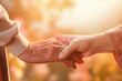 Young person's hand gently holds an elderly hand, symbolizing care, generational connection, family, support, love, or compassion, evoking feelings of hope, comfort and trust