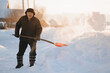 © Parilov - Elderly man cleaning snow with shovel after snowstorm, sunlight
