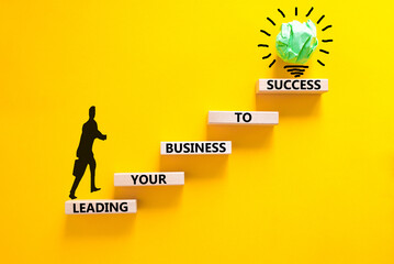 Wall Mural - Leading your business to success symbol. Concept words Leading your business to success on wooden blocks. Beautiful yellow table yellow background. Leading your business to success concept. Copy space