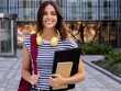 © gonzagon - Portrait of a smiling Caucasian teenage student girl with a backpack and folder looking at camera.