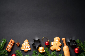 Wall Mural - Christmas baking background. Gingerbread cookies, spices and Christmas decorations at black. Top view with space for text.
