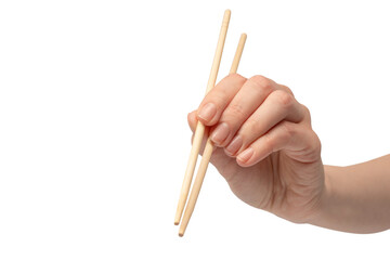 Wall Mural - Female hand holding wooden sushi chopsticks isolated on white background.