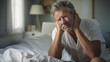 © Julija - Mature man has headaches , sitting on the bed in bedroom at home. Senior having insomnia sleeping disorder. alone at home.