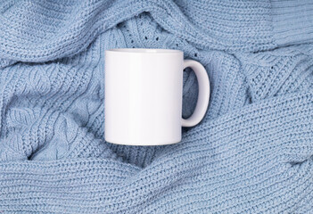 Wall Mural - Mock up white empty mug, cup for your design and logo closeup blue sweater, blanket. Template blank for promotional text message or promotional content