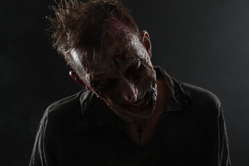 Wall Mural - Scary zombie on dark background. Halloween monster