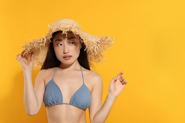 Poster - Beautiful young woman in straw hat on orange background, space for text