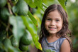 Happy Latin American little girl posing in a avocados orchards and smiling at camera