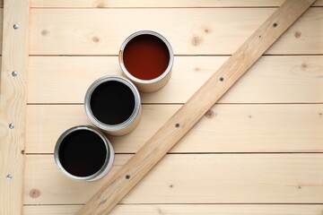 Wall Mural - Cans with different wood stains on wooden surface, flat lay. Space for text