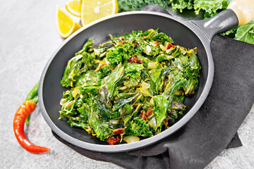 Wall Mural - Kale cabbage with orange and pepper in pan on granite table