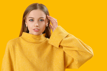 Poster - Fashionable young woman in knitted sweater on yellow background