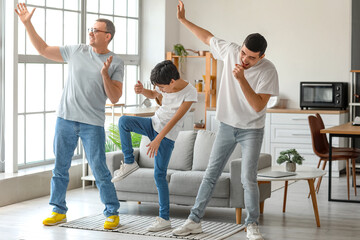 Wall Mural - Happy little boy with his dad and grandfather dancing at home
