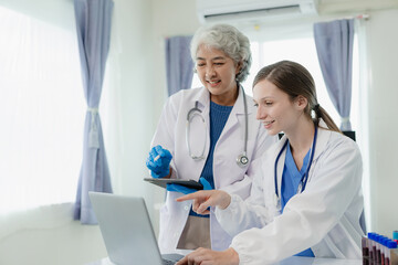 Two beautiful young scientists and elderly women work in a laboratory with test tubes and are doing some research with test tubes doing research on blue chemicals in the healthcare industry.