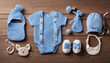 Various baby items, including clothing and a toy, laid out on a wooden surface.