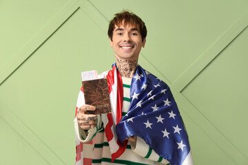 Canvas Print - Handsome young man with USA flag and passport on green background. Immigration concept