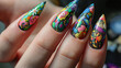An close-up view of a woman's pointed, manicured nails with a colorful floral design