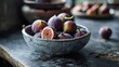  a bowl filled with lots of ripe figs sitting on top of a table next to a bowl of sliced figs.