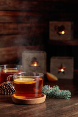 Wall Mural - Tea with lemon and small Christmas lanterns on a wooden table.