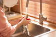Asian healthy woman washing  vegetable and other fruit above kitchen sink and cleaning.