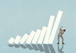 © fStop - Businessman standing under falling bar graph