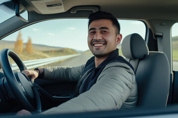 Portrait of smiling young man driving car. behind wheel looking at camera