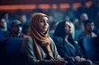 Arab girl in a burqa in a conference hall, meeting, cinema. Students sitting in the audience.