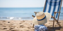 A Blue And White Beach Chair With A Straw Hat On It.