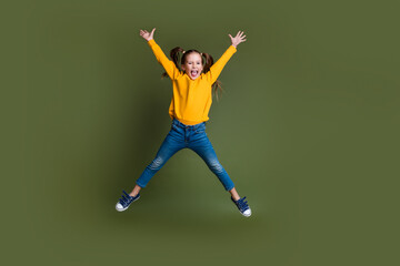 Sticker - Full length photo of good mood kid with ponytails hairdo dressed yellow shirt flying raising hands up isolated on khaki color background