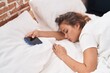 © Krakenimages.com - Young beautiful hispanic woman holding smartphnoe lying on bed sleeping at bedroom