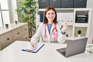 Poster - Young blonde woman doctor writing medical report holding blood test tube at clinic