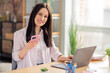© deagreez - Portrait of successful positive girl sit chair use smart phone laptop coworking bright office business center indoors