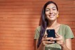 © Krakenimages.com - Young beautiful hispanic woman smiling confident using smartphone over isolated brick background