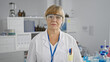 © Krakenimages.com - Serious-faced, mature, blonde scientist woman, locked in concentration at her lab table, engrossed in her cutting-edge medical research amid the hum of technology and the clink of test tubes.