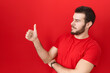 © Krakenimages.com - Young hispanic man wearing casual red t shirt looking proud, smiling doing thumbs up gesture to the side