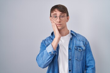 Sticker - Caucasian blond man standing wearing glasses thinking looking tired and bored with depression problems with crossed arms.