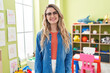 © Krakenimages.com - Young caucasian woman working as teacher at kindergarten looking positive and happy standing and smiling with a confident smile showing teeth