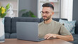 © Krakenimages.com - Young hispanic man using laptop sitting on floor at home
