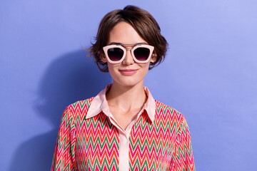 Poster - Portrait of good mood pretty girl with short haircut wear shirt in stylish sunglass look at camera isolated on blue color background