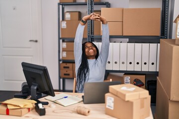 Wall Mural - African american woman ecommerce business worker using laptop stretching arms at street