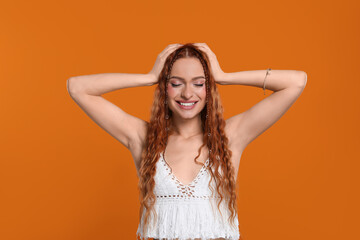 Poster - Beautiful young hippie woman on orange background