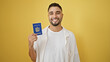 © Krakenimages.com - Smiling young man holding cuban passport against yellow background