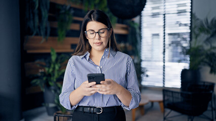 Sticker - Young beautiful hispanic woman using smartphone with serious face at the office